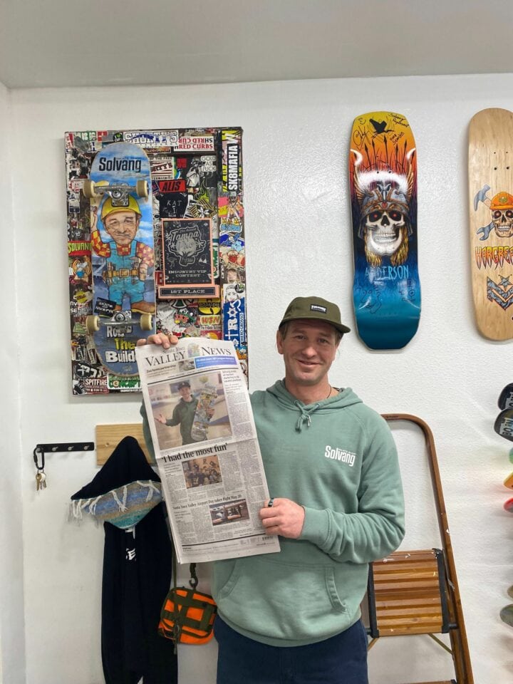 Man at skate shop holding newspaper